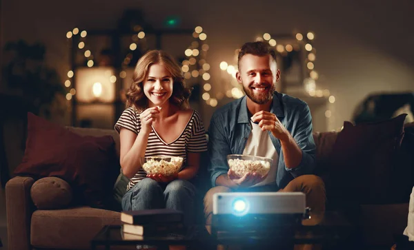 Famiglia coppia guardando proiettore televisivo a casa su sof — Foto Stock