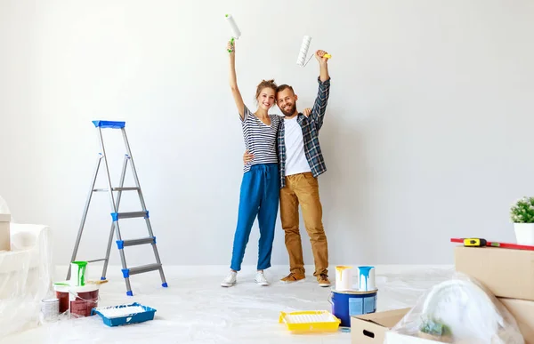 Joven feliz pareja está reparando y pintando la pared en hom — Foto de Stock