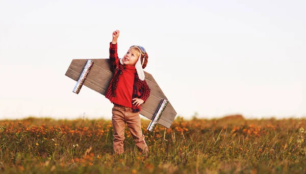 Child pilot aviator with wings of airplane dreams of traveling i — Stock Photo, Image