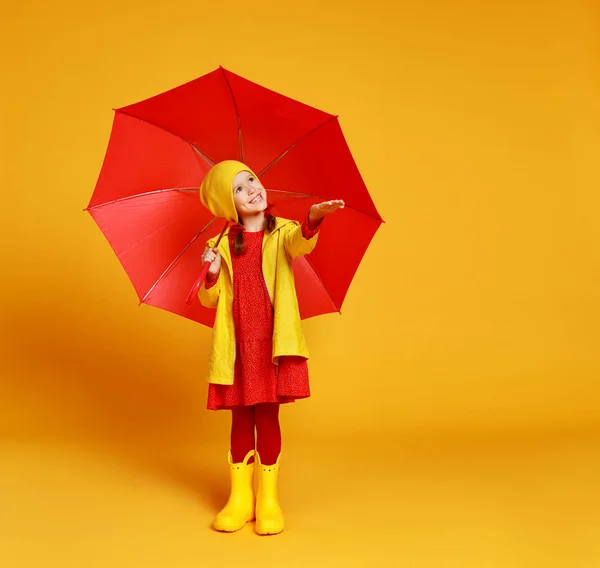 Fröhliche emotionale fröhliche Kindermädchen lachen mit rotem Regenschirm — Stockfoto