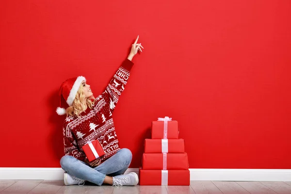 Gelukkig jong vrolijk meisje lacht en springt in kerst hoed en — Stockfoto