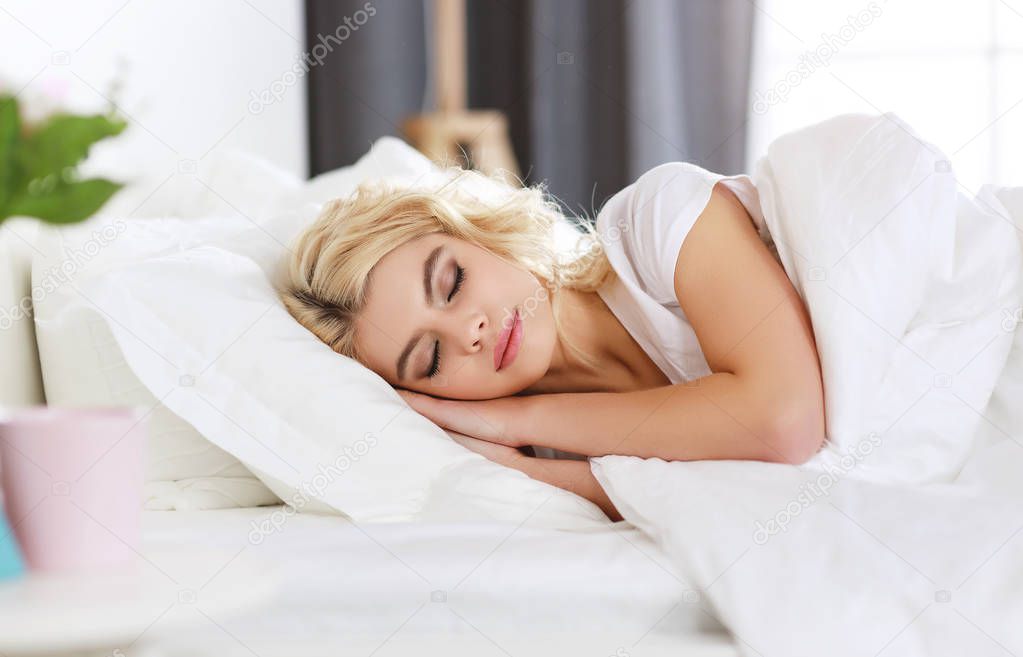 beautiful young woman sleeping in bed in the mornin