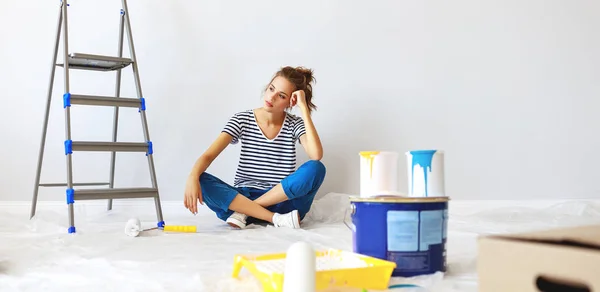 Riparazione in appartamento. stanca giovane donna dipinge muro — Foto Stock