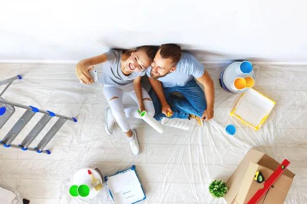 Young happy couple is repairing and painting   wall at hom — Stock Photo, Image