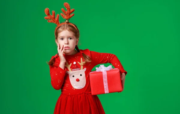 Smutný, překvapený legrační dítě dívka v červené vánoční sobí kostým — Stock fotografie