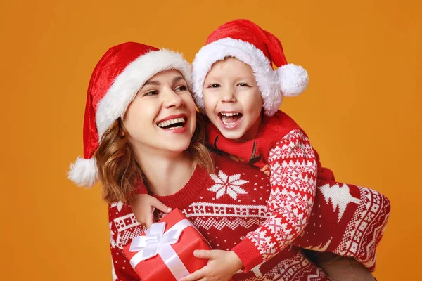 Família feliz mãe e filho filho com presentes de Natal no amarelo — Fotografia de Stock