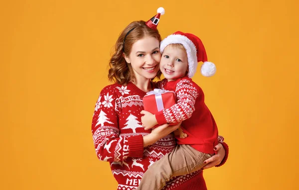 Gelukkig familie moeder en kind zoon met kerst geschenken op geel — Stockfoto