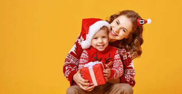 Ευτυχισμένη οικογένεια μητέρα και παιδί γιος με χριστουγεννιάτικα δώρα στο κίτρινο — Φωτογραφία Αρχείου