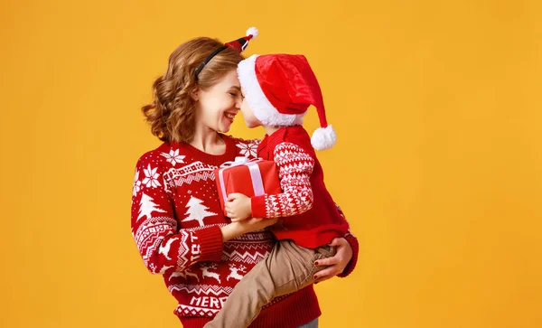 Felice famiglia madre e figlio bambino con regali di Natale su giallo — Foto Stock