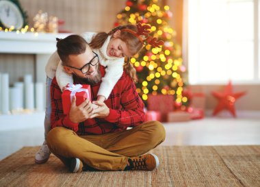 Mutlu aile babası ve kızı Noel hediyesi veriyor. 