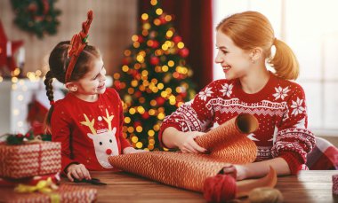 Mutlu aile annesi ve çocuğu Noel hediyelerini eve yakın bir yere koyarlar. 