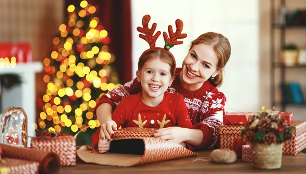 Ευτυχισμένη οικογένεια μητέρα και το παιδί πακέτο χριστουγεννιάτικα δώρα στο σπίτι κοντά — Φωτογραφία Αρχείου