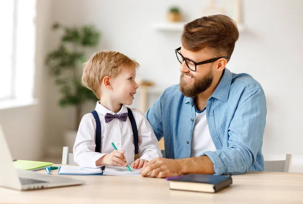 Giovane Uomo Barbuto Occhiali Aiutare Sorridente Bambino Con Compiti Mentre — Foto Stock