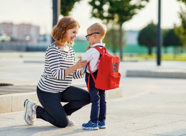 Okuldaki ilk günüm. Anne, küçük okul çocuğunun yanına diz çöktü.