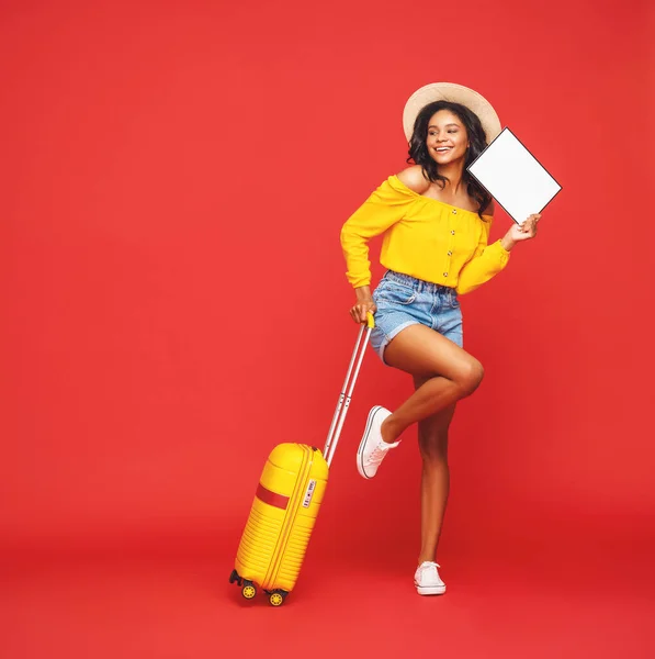 全长乐观的女性游客 提着手提箱和空白海报 面带微笑 望着红色的背风 — 图库照片