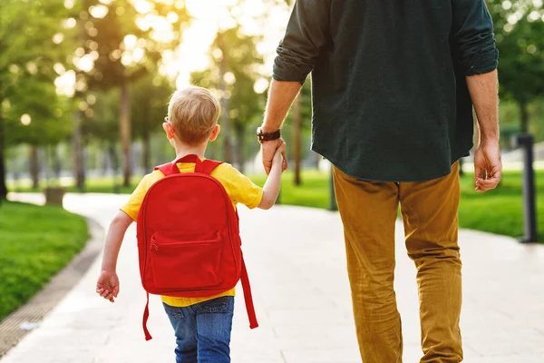 Vista Posterior Cosecha Padre Hijo Con Mochila Cogidos Mano Mientras —  Fotos de Stock