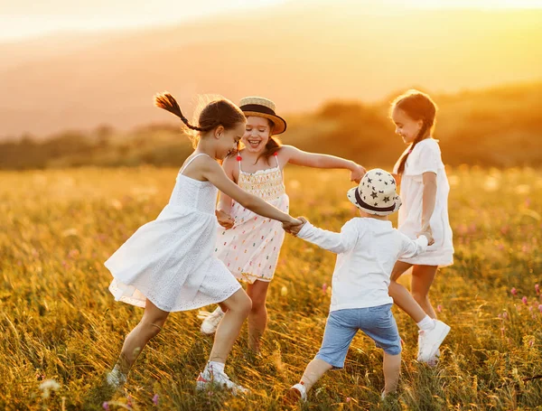 一个可爱的小女孩 与弟弟在乡间的绿地上度过夏天的夜晚 一边玩耍 一边跳舞 — 图库照片