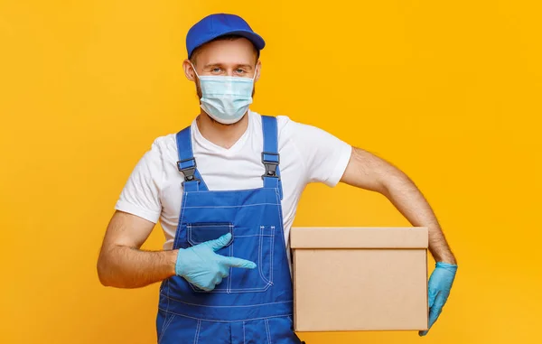 Male Courier Uniform Protective Accessories Pointing Carton Box Looking Camera — Stock Photo, Image