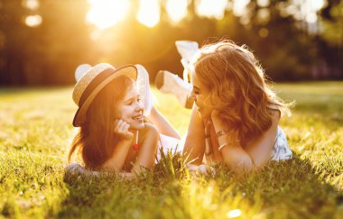 Mutlu aile anne ve kızı doğada Yazın yeşil gras üzerine park