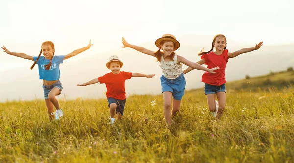 穿着休闲装的快乐的孩子们 在日落时一起在绿地里玩耍 一起跑步 在乡间度过暑假 — 图库照片