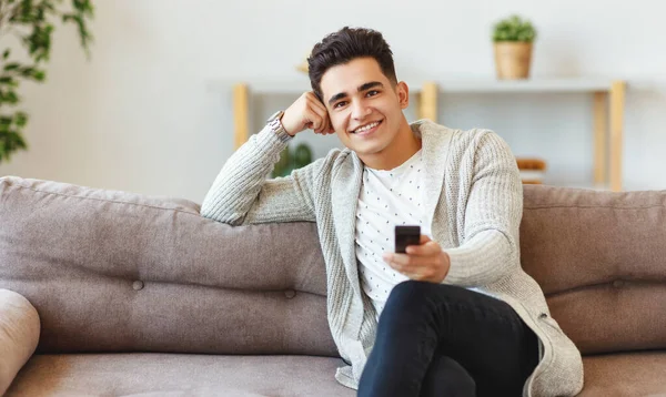 Feliz Jovem Étnico Cara Sorrindo Mudando Canais Com Controle Remoto — Fotografia de Stock