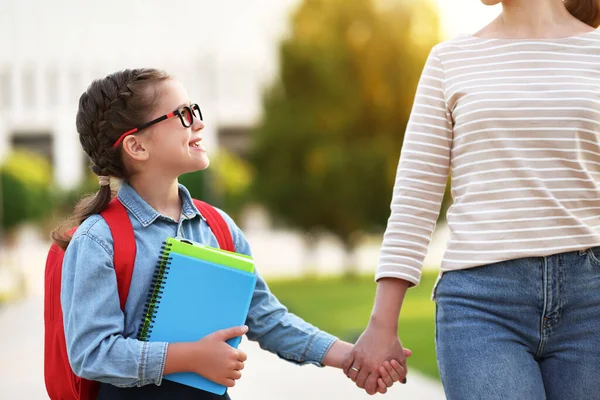 Feliz Chica Inteligente Con Cuadernos Sonriendo Mirando Madre Cosecha Mientras —  Fotos de Stock