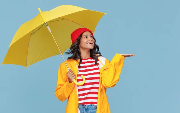 黄色の傘の笑顔と青を背景に雨の秋の日に雨滴をキャッチと陽気な民族の女性 — ストック写真