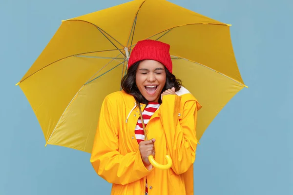 陽気な民族の女性とともに黄色の傘叫びで閉じた目で上の雨の秋の日に青 — ストック写真