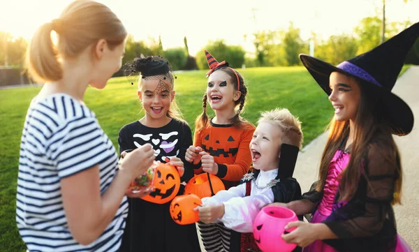 Szczęśliwy Dzieci Strojach Karnawałowych Poprosić Matkę Cukierki Słodycze Halloween — Zdjęcie stockowe