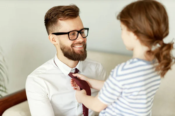 認識できない小さな女の子調整ネクタイの幸せなお父さん身に着けていますフォーマルスーツと眼鏡中準備のためにビジネスミーティングで自宅 — ストック写真