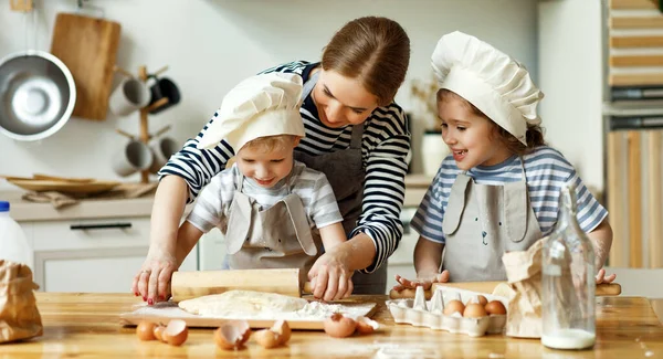 Jovem Mãe Feliz Crianças Pequenas Chapéus Chef Rolando Massa Juntos — Fotografia de Stock