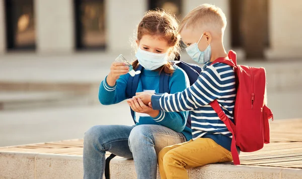 Kleine Zus Broer Beschermende Maskers Met Schoolrugzakken Desinfecteren Handen Met — Stockfoto