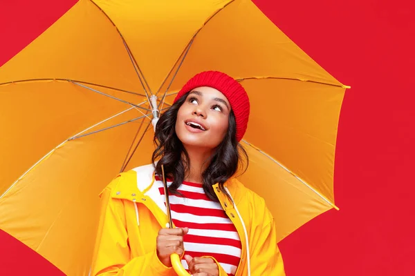 幸せ若いですエスニック女性で傘を見上げ 夢を見ながら雨の中で赤を背景に — ストック写真