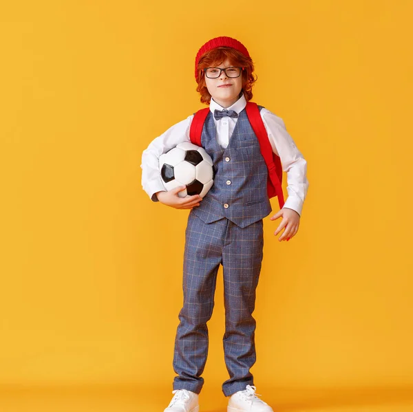 Snygg Pojke Skoluniform Bär Fotboll Efter Studier Mot Gul Bakgrund — Stockfoto
