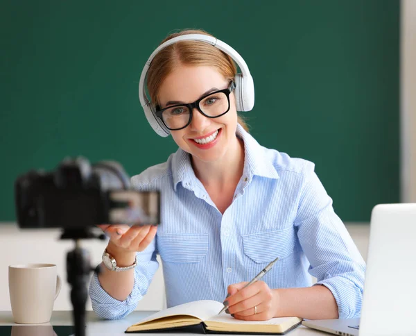 ヘッドフォンやメガネで陽気な大人の女性は笑顔と教室でビデオを記録しながら オンライン学生と話す — ストック写真