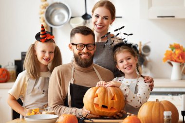 Balkabaklı mutlu aile ve kızlar. O fener gülümsüyor ve evde Cadılar Bayramı kutlaması sırasında kameraya bakıyor.