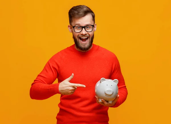 Delighted Bearded Man Glasses Smiling Camera Pointing Piggy Bank Savings — Stock Photo, Image