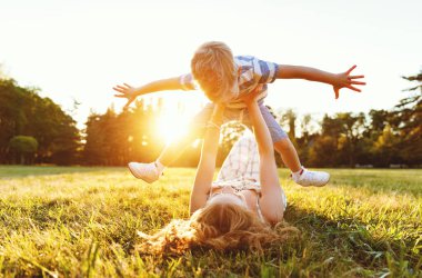 Mutlu aile: Anne çimlerin üzerinde uzanıyor ve doğaya kusuyor.