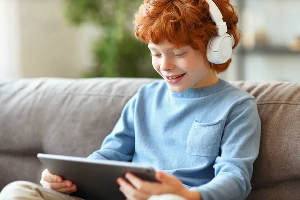 Alegre Niño Jengibre Auriculares Sonriendo Mientras Está Sentado Con Las —  Fotos de Stock