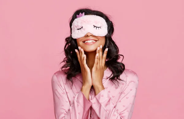 在睡前日常护肤过程中 穿着睡衣的快乐女性 并在脸上涂上微笑和污迹性乳液 以防止粉红背纹 — 图库照片