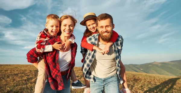幸福的家庭 儿子和女儿抱在一起 欢笑着 在草地上玩着 在大自然中和蓝色的天空嬉笑着 — 图库照片
