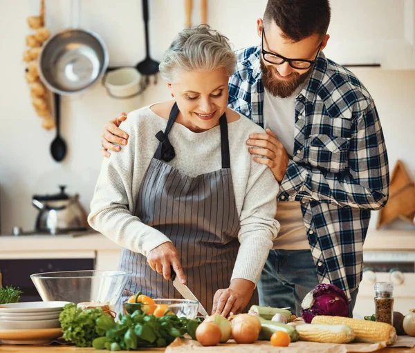 Cheerful Young Bearded Man Embracing Happy Mature Mother Apron Preparation — Stock Photo, Image