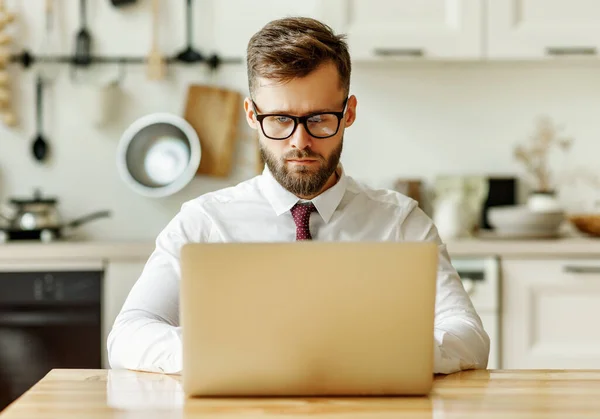 以年轻男性创业者为重点 穿着正式衬衫打领带 坐在桌旁 在自我隔离期间上网工作时使用笔记本电脑 — 图库照片