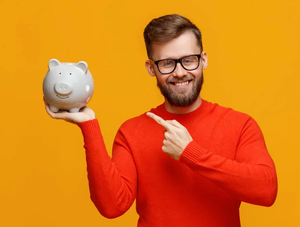 Delighted Bearded Man Glasses Smiling Camera Pointing Piggy Bank Savings — Stock Photo, Image