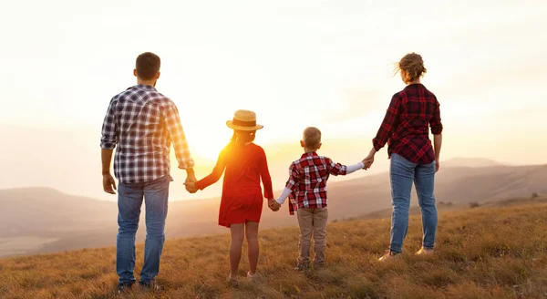 幸福的家庭 儿子和女儿背对着大自然 在阳光下手牵着手 — 图库照片