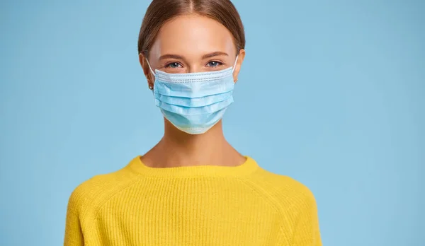 Beautiful Young Woman Protective Medical Mask Yellow Sweater Blue Background — Stock Photo, Image