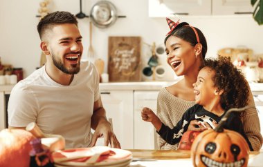 Mutlu çok ırklı aile anne, baba ve küçük oğul Cadılar Bayramı 'nı evde kutlayın.