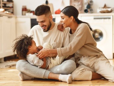 Mutlu aile çok ırklı anne, baba ve oğul gülüyor, oynuyor ve yatak odasında gıdıklanıyor.