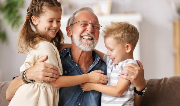 Fröhlich Gealterter Mann Lächelt Und Umarmt Süße Jungen Und Mädchen — Stockfoto