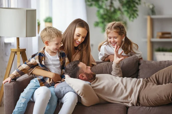 Mutlu aile, anne, baba ve çocuklar kanepede.